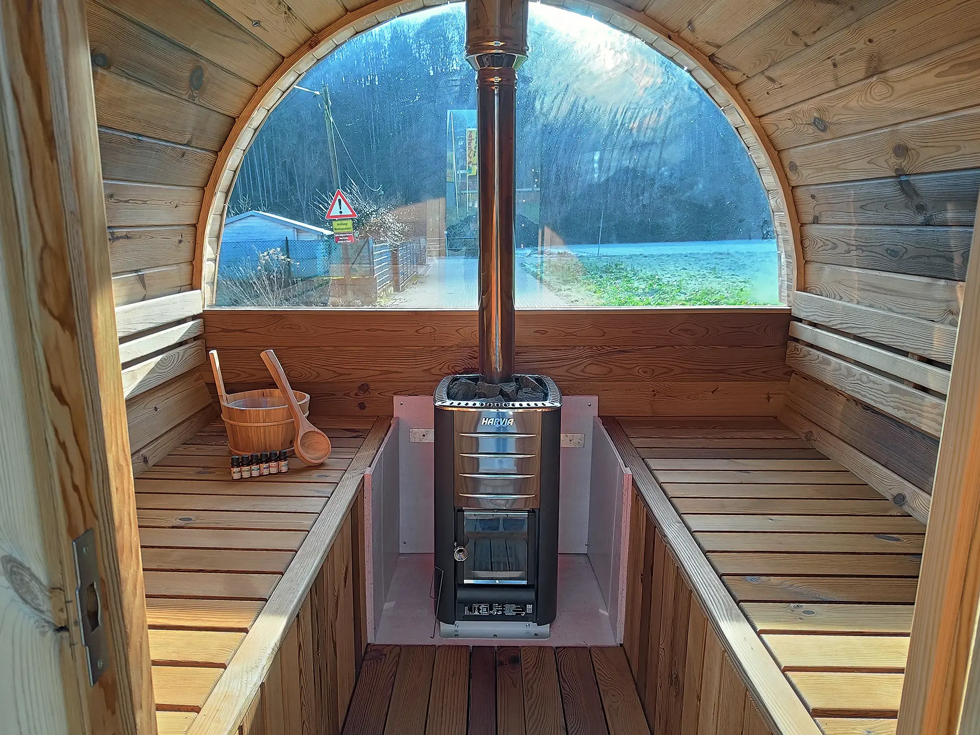 Innenraum von der Fasssauna von Fassglück in Hennef (Sieg) mit wunderschönem Blick in die Natur aus dem Panoramafenster