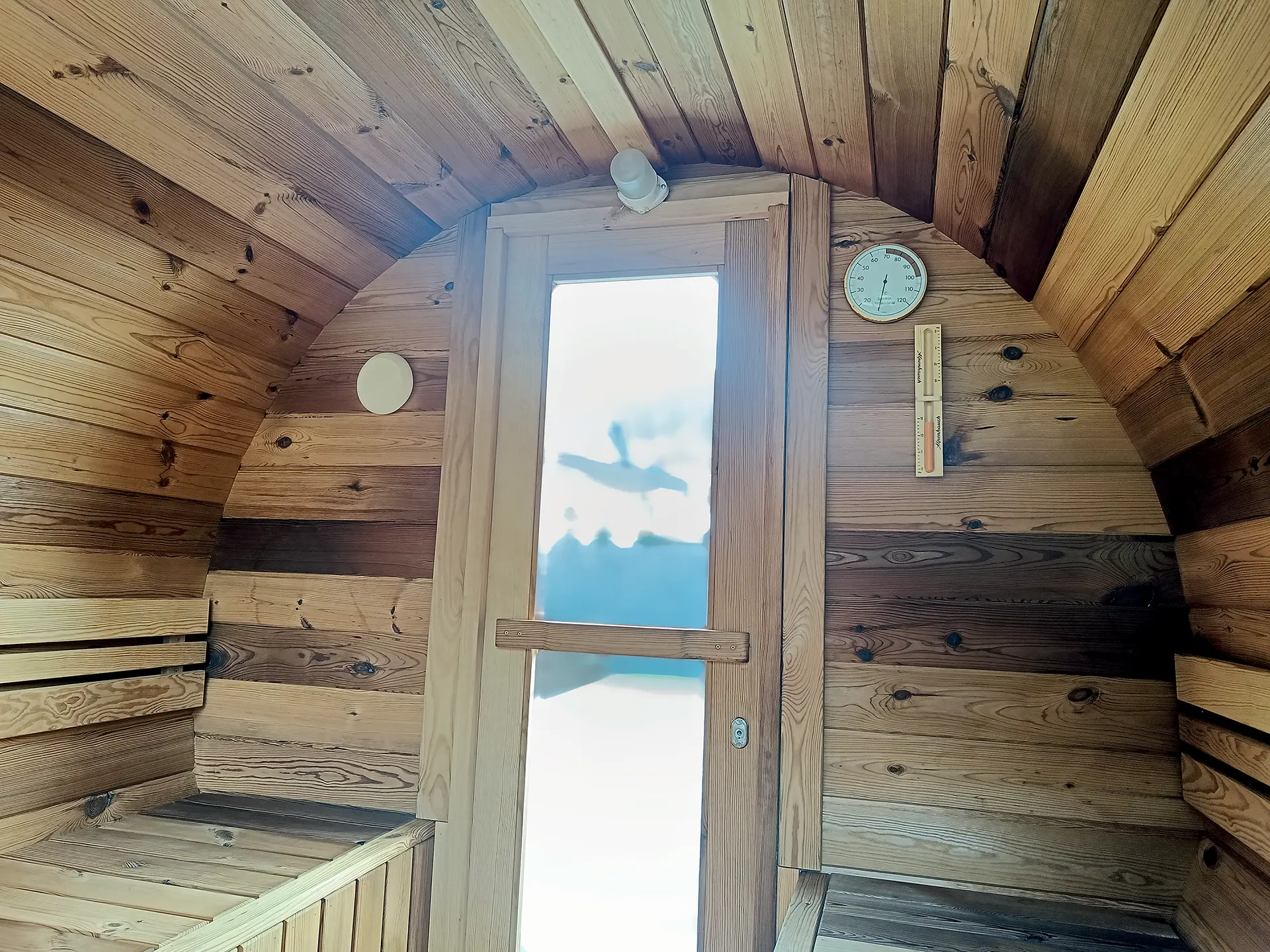 Innenraum von der Fasssauna von Fassglück in Hennef (Sieg) mit Thermometer und Sanduhr